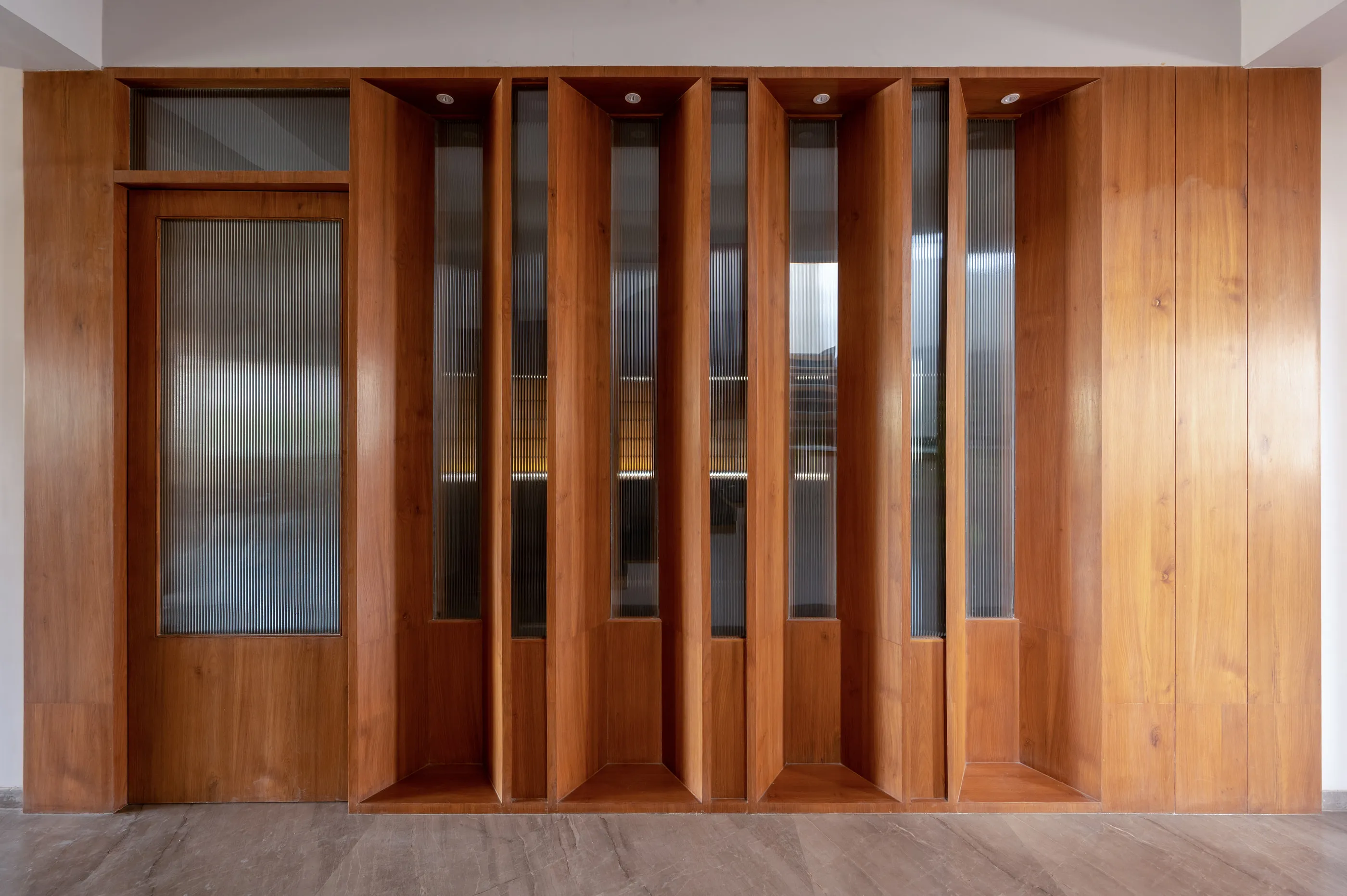 A tall timber screen with fluted glass panels